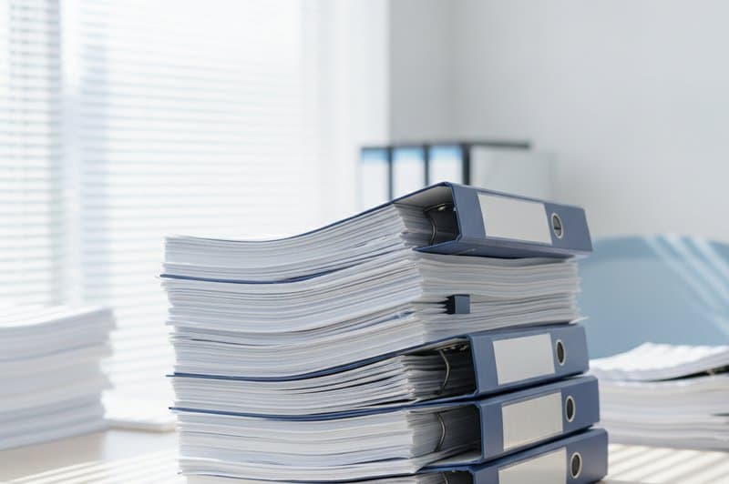 机に積み上がった書類とファイル